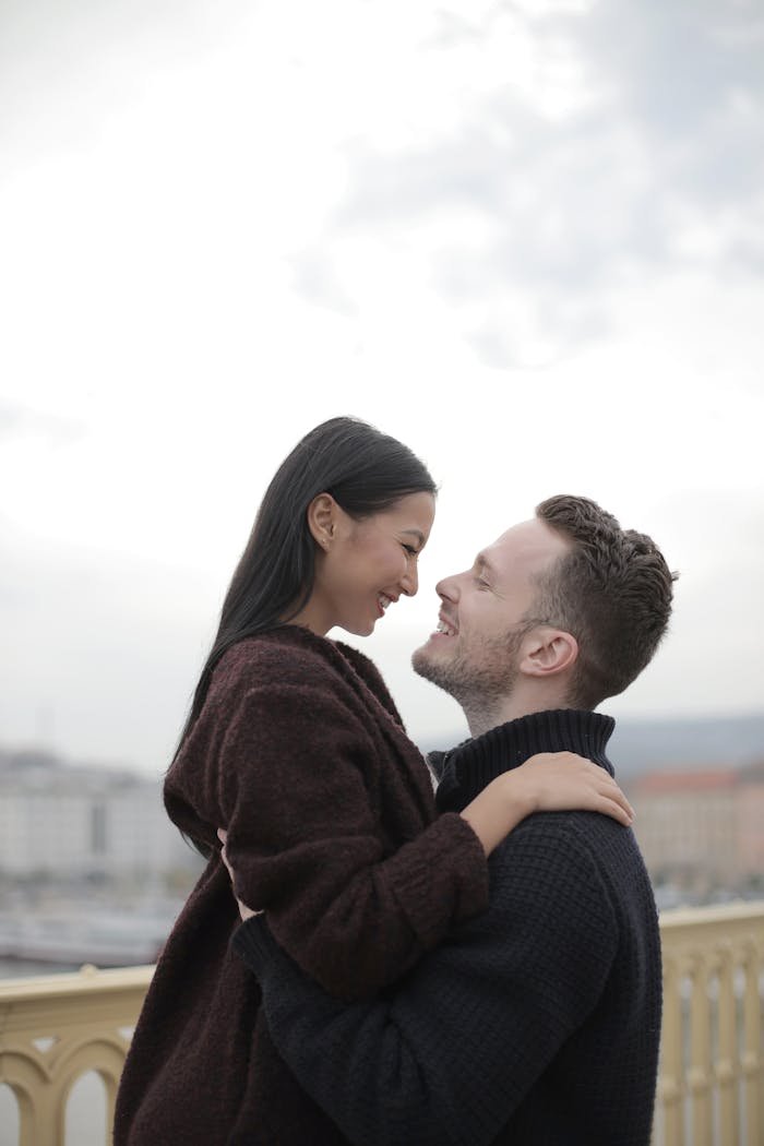 A loving couple sharing an embrace outdoors, highlighting romance and intimacy.